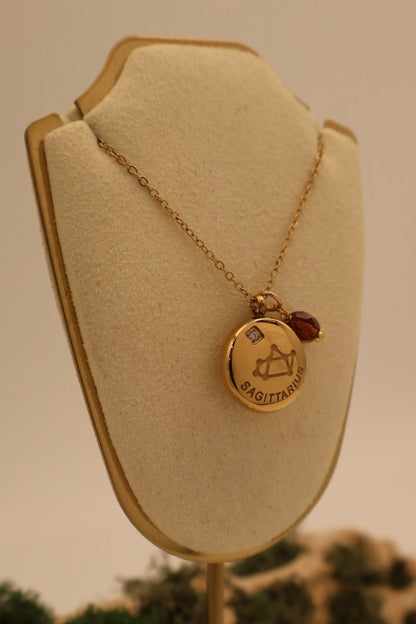 Gold necklace with a pendant on a beige bust