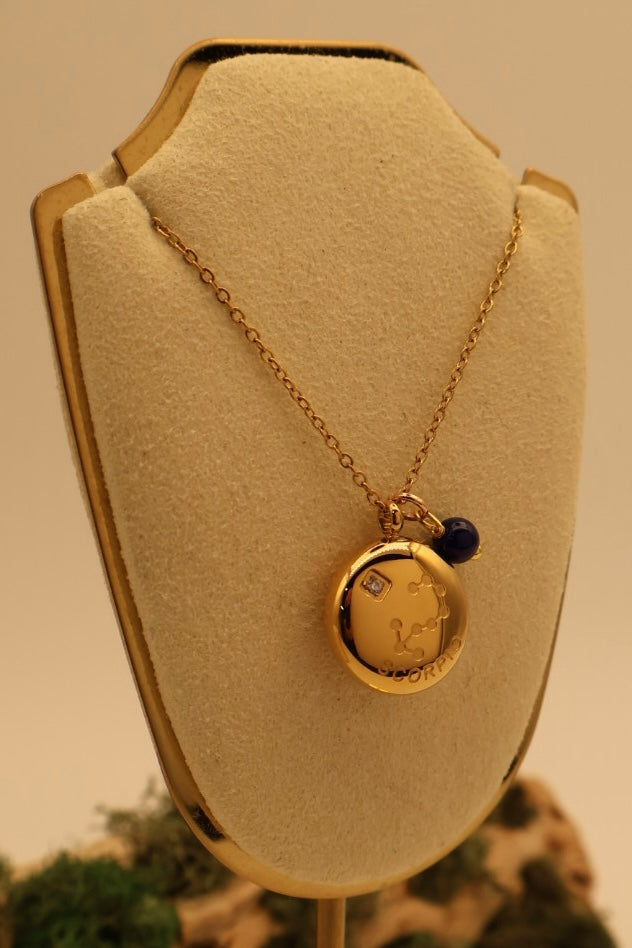 Gold necklace with a pendant on a beige bust