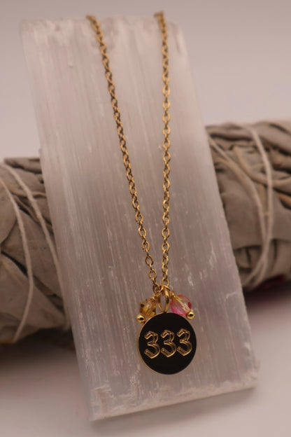 Necklace with a black pendant featuring the number '333' on a white background