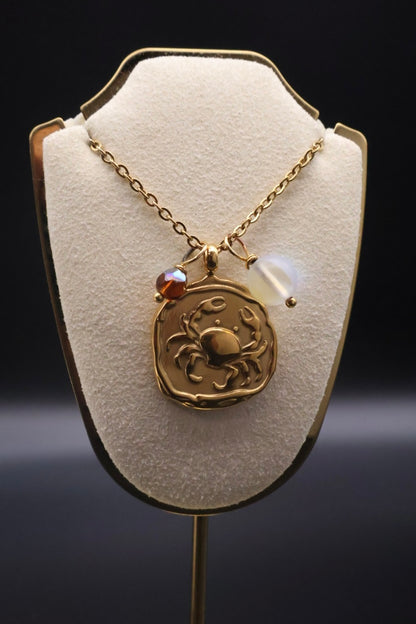 Gold necklace with a pendant on a white stand against a dark background