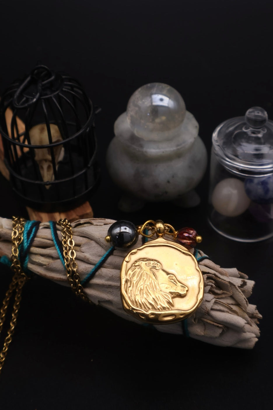 Gold lion pendant on a cloth with mystical items in the background