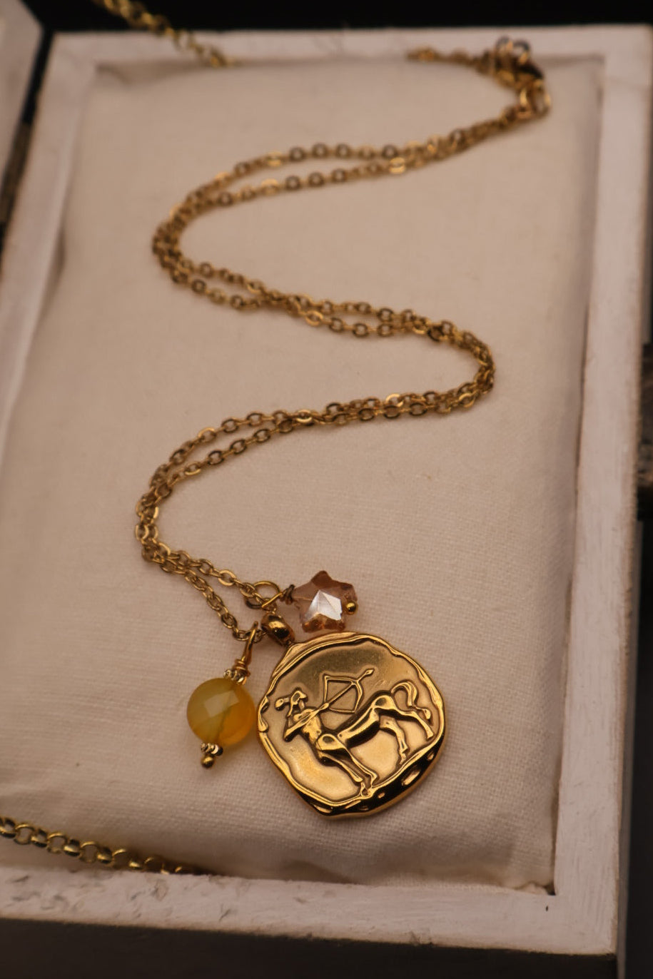 Gold necklace with a pendant on a textured surface