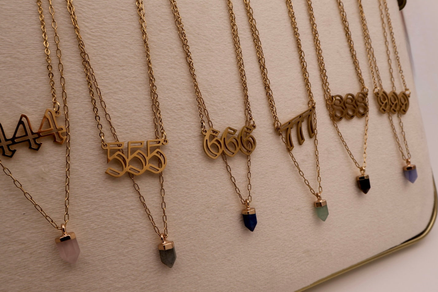 Gold necklaces with various pendants on a light surface