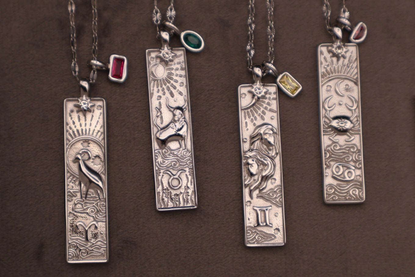 Set of silver pendants on chains against a brown background