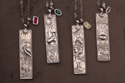 Set of silver pendants on chains against a brown background
