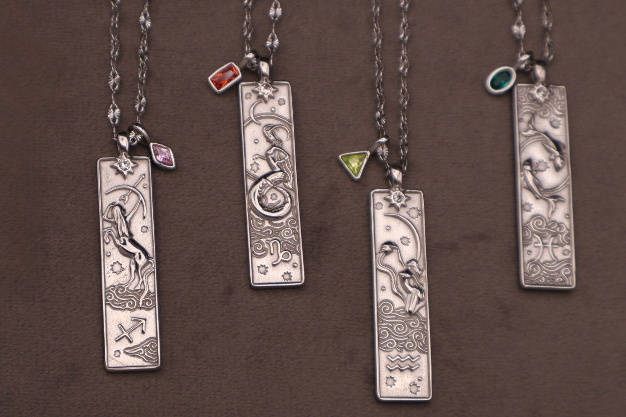 Set of silver necklaces with rectangular pendants on a brown background