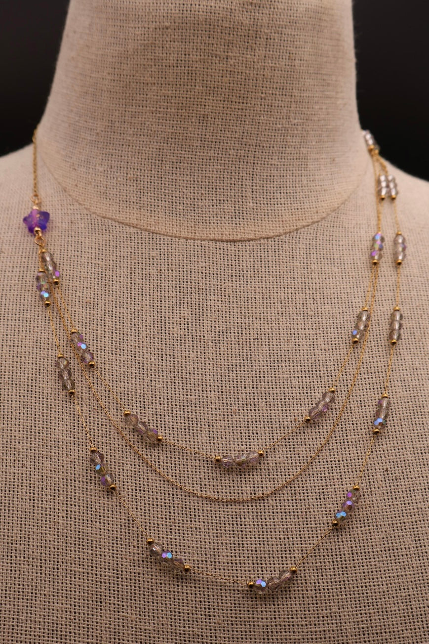 Necklace with beads on a mannequin bust against a black background