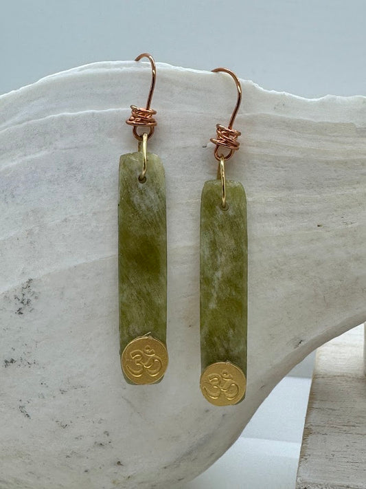 Model wearing Gemstone Earrings, highlighting the radiant colors of the gemstones as they dangle gracefully from the ears.