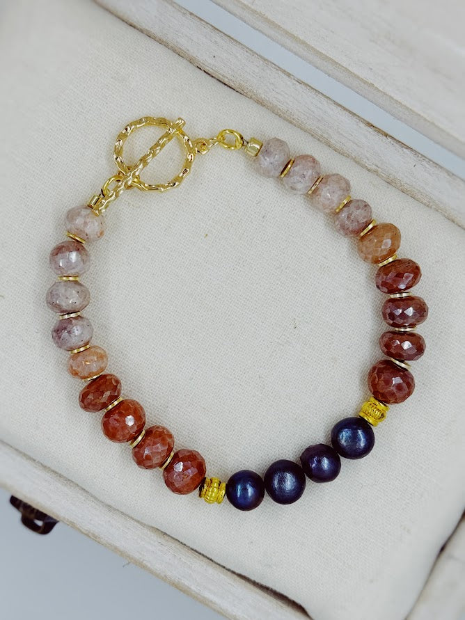 a bracelet with black peal beads and sunstone beads