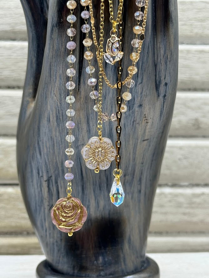 a closeup of flower beads hanging on gold chains