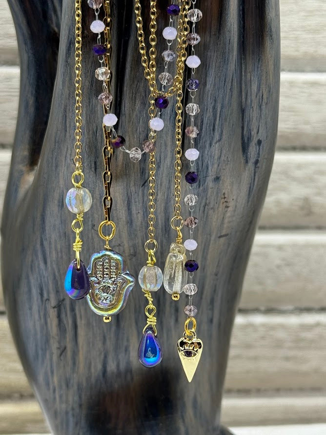 charms and beads hanging off gold and beaded chains