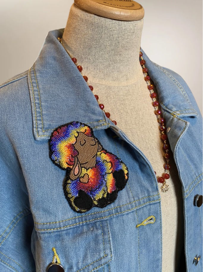 A rainbow sheep on a denim jacket